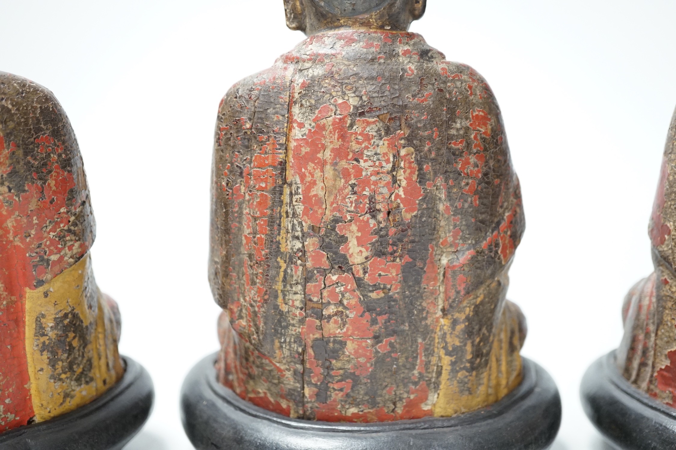 A set of three Chinese polychrome lacquered wood seated figures of Buddha, 19cm